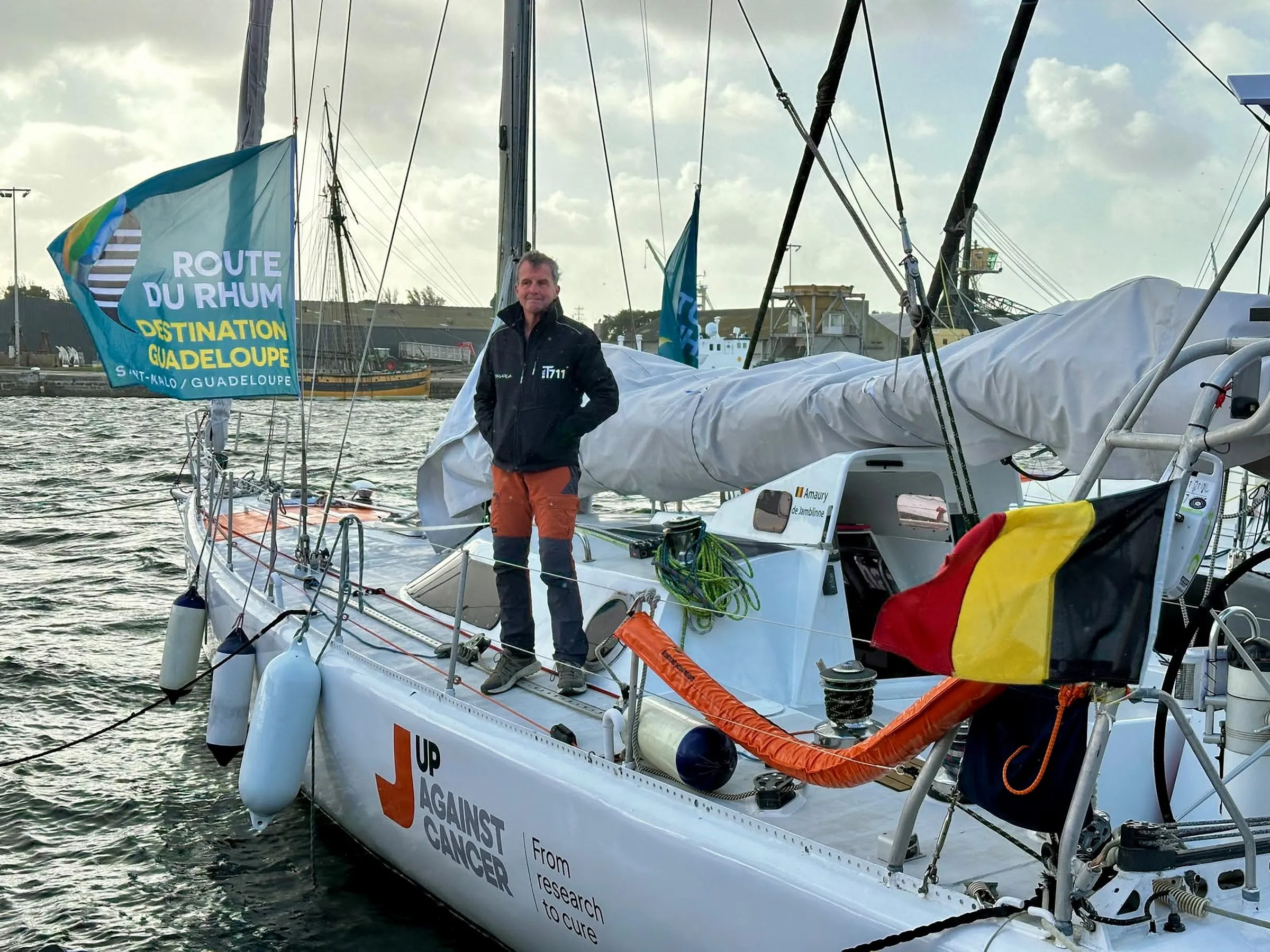 Amaury sur le pont de Tagaroa à Saint-Malo, avec le pavillon de la Route du Rhum et le drapeau belge